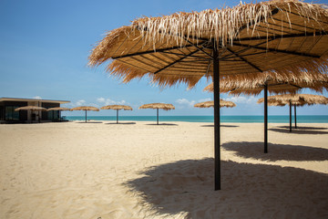 Straw umbrella on the beach for summer vacation tropics,Concept: Lifestyle for leisure travel,symbol tourism for island By the sea