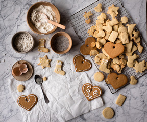 Selbst gebackene Weihnachtsplätzchen auf einem Marmortisch warten auf Verzierung