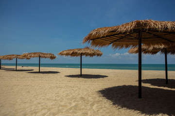 Straw umbrella on the beach for summer vacation tropics,Concept: Lifestyle for leisure travel,symbol tourism for island By the sea