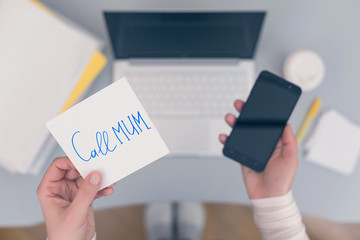 Woman clerk is sitting at office table holding note sticker with message 