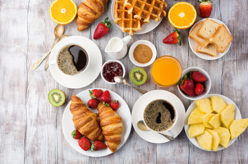 Fototapeta na wymiar Continental breakfast table with coffee, orange juice, croissants