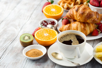Continental breakfast table with coffee, orange juice, croissants
