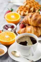 Continental breakfast table with coffee, orange juice, croissants