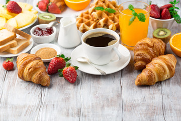 Continental breakfast table with coffee, orange juice, croissants