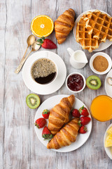 Continental breakfast table with coffee, orange juice, croissants