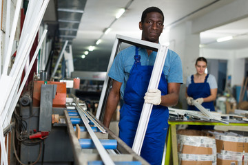 Portrait of man worker who is standing with window frame