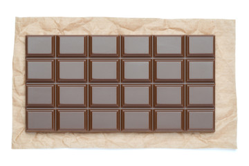 milk chocolate bar on craft packaging paper isolated on white background with clipping path
