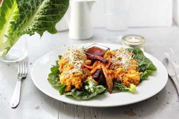 Baked vegetables, sweet potato, potato, celery, carrot, beet served with vegetable stew on iceberg lettuce.