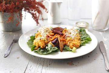 Baked vegetables, sweet potato, potato, celery, carrot, beet served with vegetable stew on iceberg lettuce.
