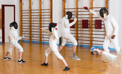 Mixed  group of fencers trains in pairs