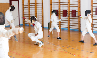 Young fencers training with coach