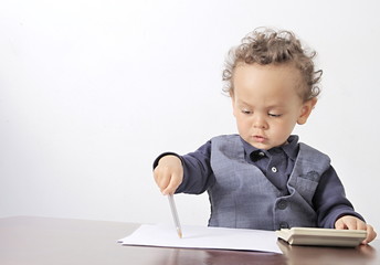 little boy with calculator and pen on table with white background stock photo