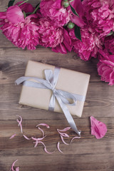Pink peony flowers gift box cup on brown rustic table. Mothers day or Womens day