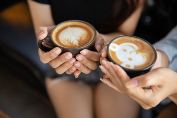 Female hands holding cups of coffee.