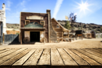 Wooden old table of free space for your product. Blurred background of Wild West city in America. 