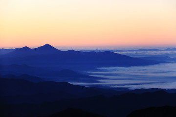 Fototapeta premium 東北飯豊山 山頂直下本山小屋から 朝焼けに煙る会津磐梯山と雲海の下に眠る会津の街と猪苗代湖