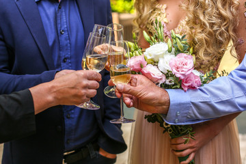 Bridal couple holding champagne and wedding bouquet