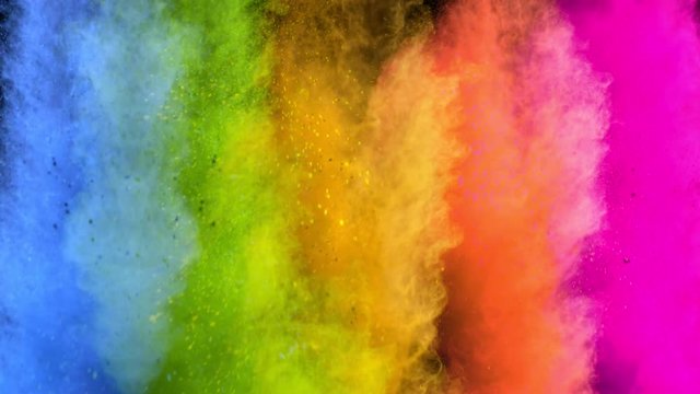 Super slowmotion shot of color powder explosions isolated on black background.