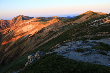 東北飯豊連峰　飯豊山山頂直下本山小屋の朝　朝陽に映える飯豊本山と大日岳の雄姿と稜線