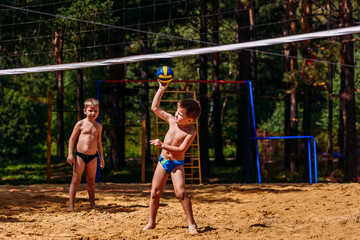 small happy children playing beach volleyball