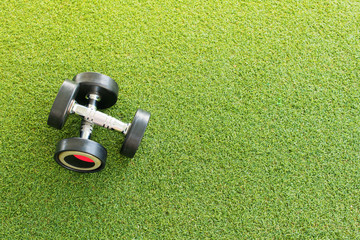 Two weights dumbbell on green grass background