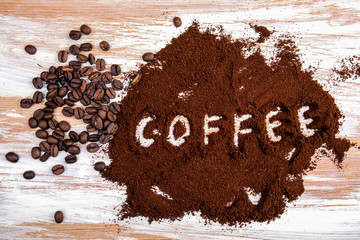 Ground coffee and coffee beans on a wooden background