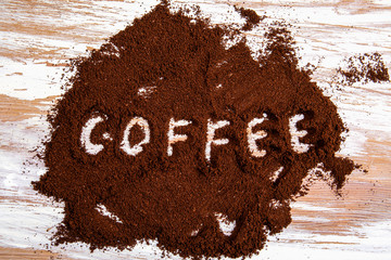 Ground coffee on wooden background