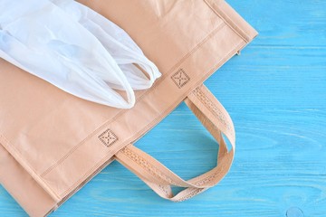 Plastic bag and cotton bag with selective focus on blue background. Zero waste concept. Reduce...
