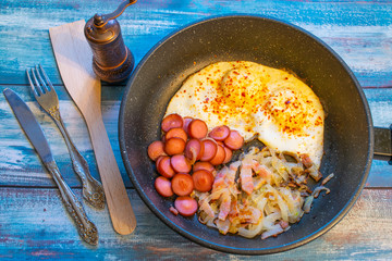 Scrambled eggs with bacon, onion and sausage.