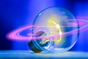 The light bulb with a flash of yellow light in, with a ring of purple light, isolated on electrical...