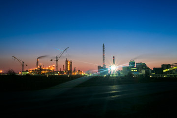 Fototapeta na wymiar chemical plant in a silhouette image at sunset, the glowing light of the chemical industry at sunset and twilight sky, the field of chemistry