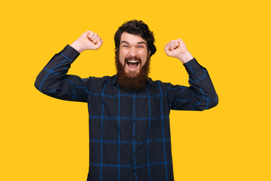 Handsome Bearded Man Making A Winner Gesture And Making An Excited Face. Yes! Yay!