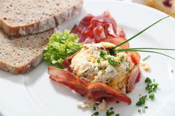 Scrambled eggs with chives and fried bacon.