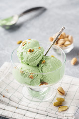 Pistachio ice cream in a bowl with chopped nuts