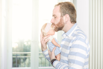 Fototapeta premium Redhead Man with Beard Kissing a Doll On Its Forehead