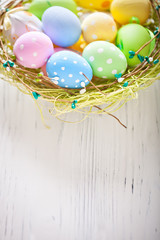 Happy Easter. Congratulatory easter background. Easter eggs and flowers. Background with copy space. Selective focus. Top view.