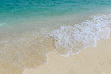 Fototapeta na wymiar Waves splashing on white beach