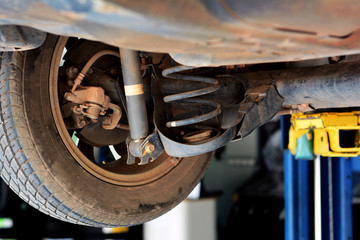 the under view of the whell,tire ,shock up and spring of the   car at repair shop