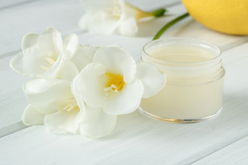 Natural cosmetic cream with spring flowers on a white table