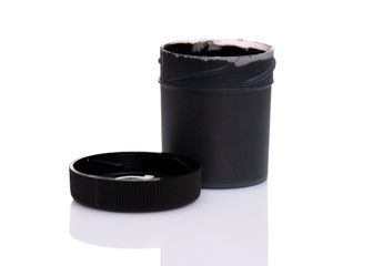 Opened black Gouache jar, isolated on white background with copy space. Cans of different colors...