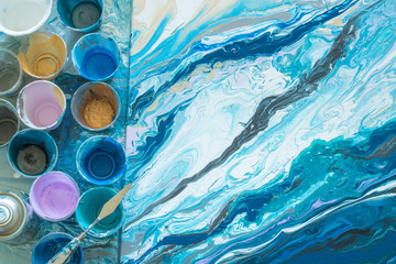 The process of creating a picture of abstraction in the technique of fluid art liquid acrylic