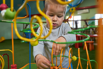 Portrait of boy playing educational toy for brain development