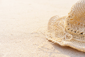 Fototapeta na wymiar Background of Sand beach with accessories straw hat in summer time. Can add text to the left.