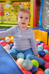 Fototapeta na wymiar Little boy playing with colorful balls
