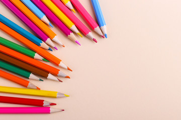 Colored pencils, on coral background, pattern, copy space.