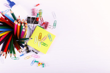 Colored pencils, paper clips and pins, school supplies for drawing, copy space.