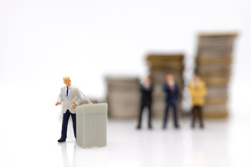 Miniature people:  Businessman standing on the stack of coins. Image use for business concept.