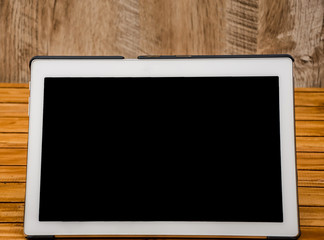 white tablet on wooden background