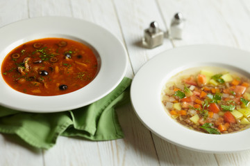soup, borscht in white plates on a green napkin