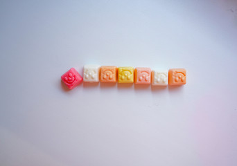 delicious square bright candy with smile on white background